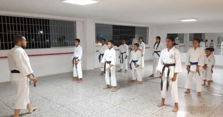 Profesor de karate dando charla reflexiva a grupo de alumnos luego de clase 