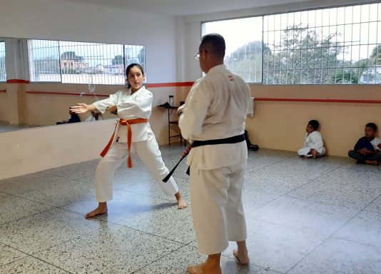 instructor de karate detallando explicación técnica a alumna