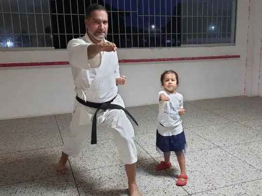 Instructor de karate enseña técnica a niña pequeña