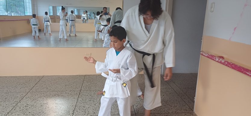 Alumno siendo guiado detalladamente por su profesora de karate